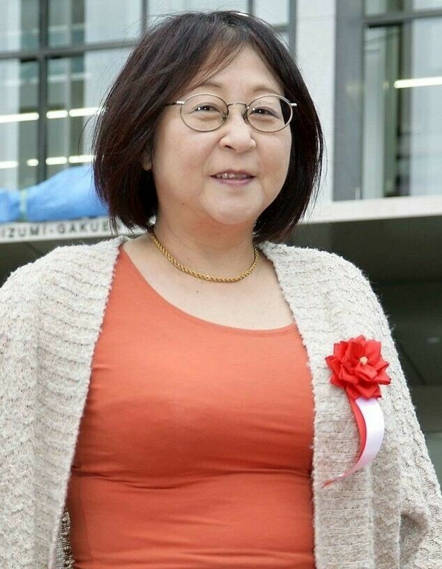 Portrait de Rumiko Takahashi, portant des lunettes et une veste claire